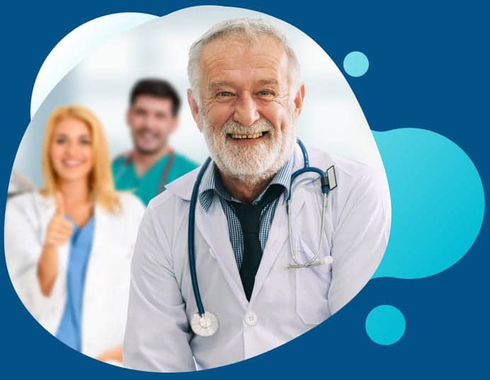 A mature medical doctor smiling as some of his colleagues stand in the background