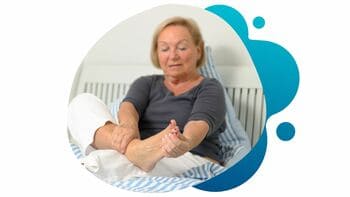 A mature woman with DPN touching her feet in discomfort and pain