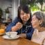 Daughter feeding elderly mother with soup.